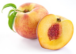 Ripe peach fruit with leaves and slises on white background.